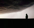 Silhueta de um homem olhando para o céu nublado, Colorado, Estados Unidos.
